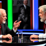 ALT: Gerry Scotti sorprende De Martino in diretta a Affari Tuoi con un gesto inaspettato che scatena ilarità tra il pubblico.