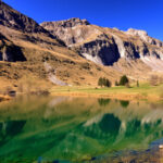 "Lago di Place-Moulin in Valle d'Aosta, turchese incantevole in primavera."