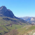 "Panorama della Val di Non con frutteti, castelli storici e montagne, ideale per escursioni tranquille."